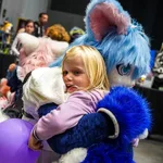 Enfant dans les bras d'un costume furry