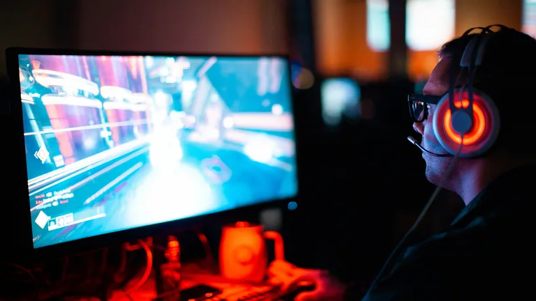 Joueur PC gamer portant un casque devant son écran d’ordinateur